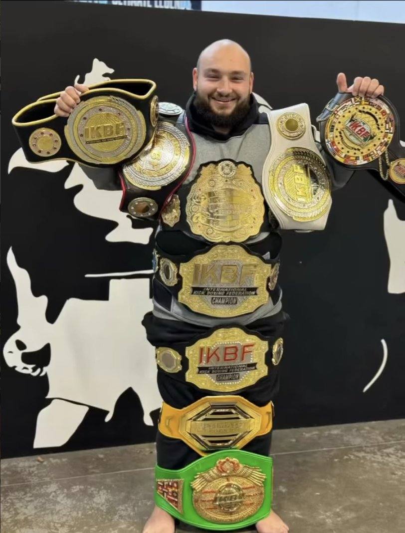 Mini Nachar holding his championship belts